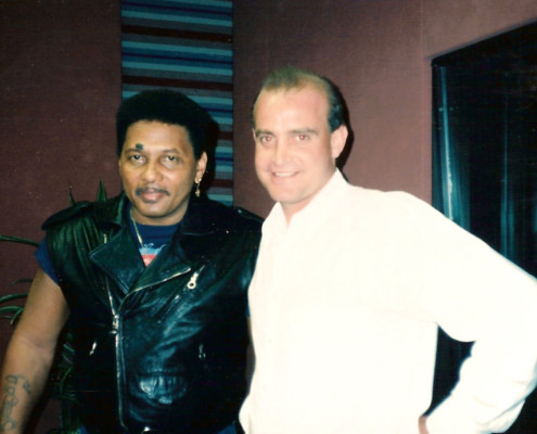 Two men standing next to each other in a recording studio.