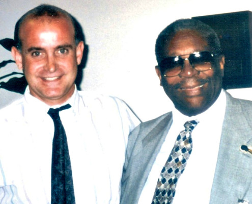 A man in a suit and tie standing next to another man.