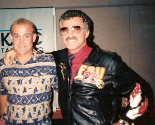 Two men posing for a photo in front of a microphone.