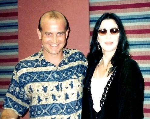 A man and woman posing for a picture in a recording studio.