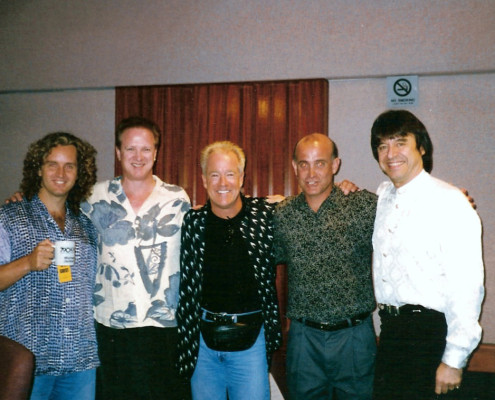 Four men posing for a picture in a recording studio.