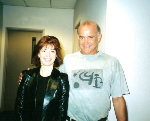 A man and woman standing next to each other in a hallway.