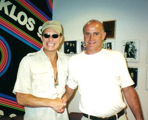 Two men shaking hands in front of a kloos sign.