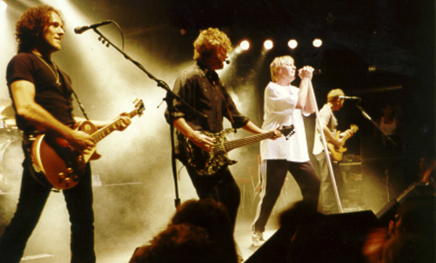 A group of men playing guitars on stage.