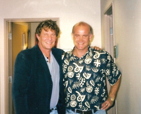 Two men standing next to each other in a hallway.