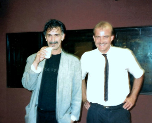 Two men standing next to each other in a recording studio.