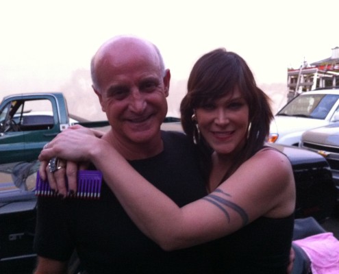 A man and a woman hugging in front of a truck.