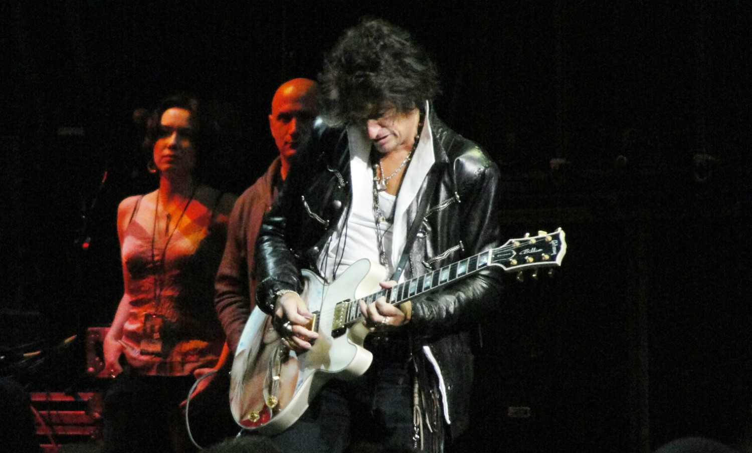 A man playing an electric guitar on stage.