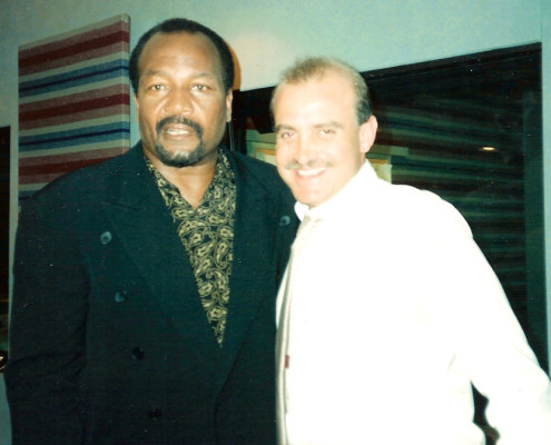 Two men standing next to each other in a recording studio.