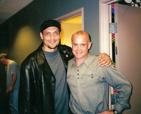 Two men standing next to each other in a hallway.