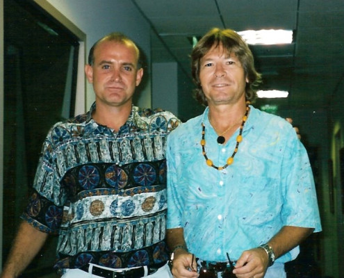 Two men standing next to each other in a hallway.