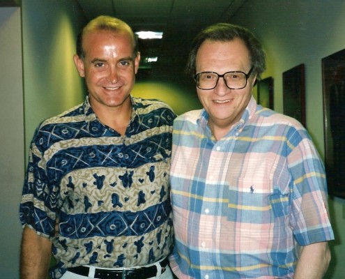 Two men standing next to each other in a hallway.