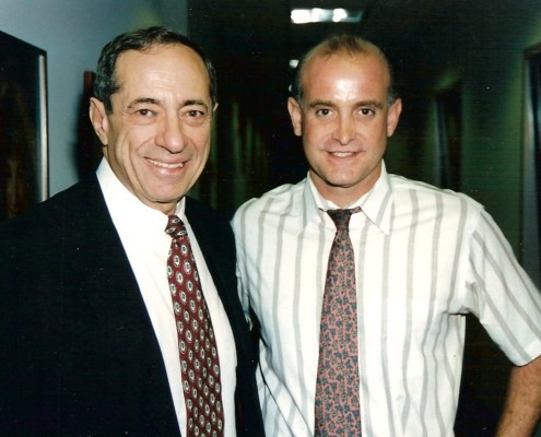 Two men standing next to each other in a hallway.