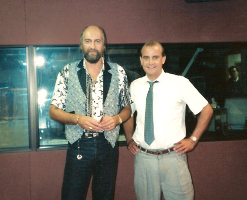 Two men standing next to each other in a recording studio.