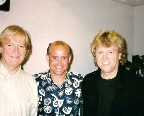 Three men posing for a photo in an office.