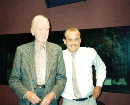 Two men standing next to each other in a recording studio.