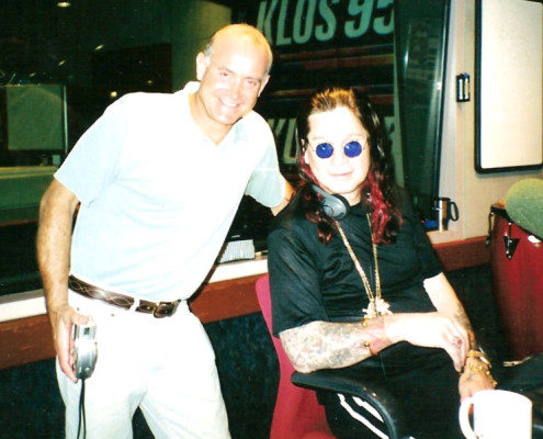 Two men posing for a photo in a radio studio.