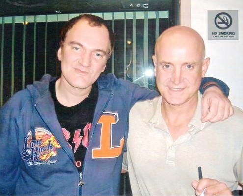 Two bald men standing next to each other.