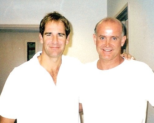 Two men in white shirts standing next to each other.