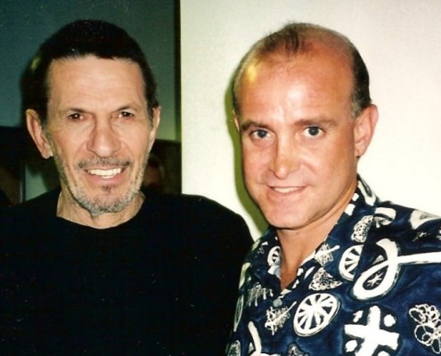 Two men posing for a photo in a hawaiian shirt.