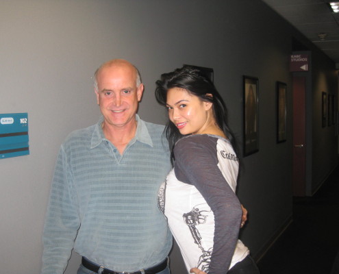 A man and a woman posing for a picture in a hallway.