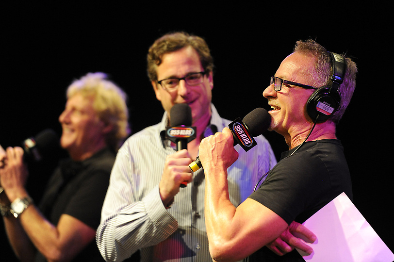 A man is holding a microphone and another man is holding a microphone.