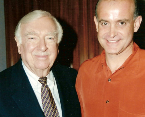 A man in an orange shirt and a man in a red shirt.