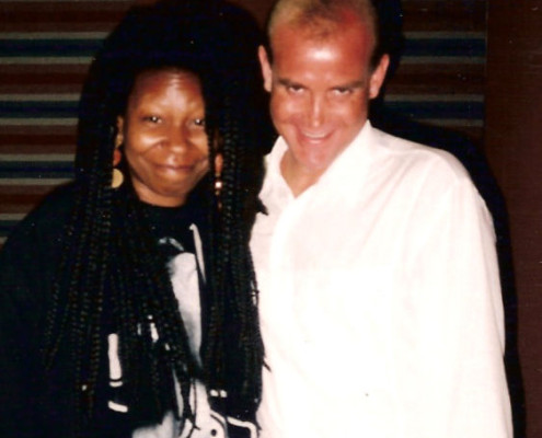 A man and a woman posing for a photo in a recording studio.