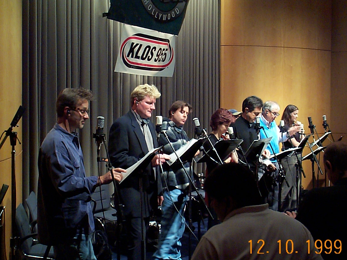 A group of people singing into microphones.