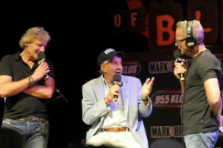 A group of people standing on stage with microphones.