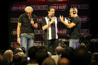 A group of men standing on stage with microphones.