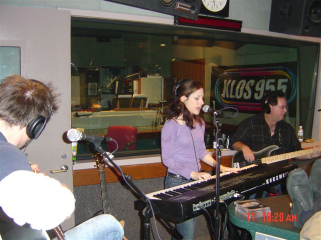 A woman and man playing piano in front of a microphone.