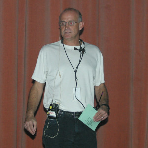 A man standing in front of a red wall.