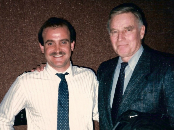 Two men in suits and ties posing for a picture.